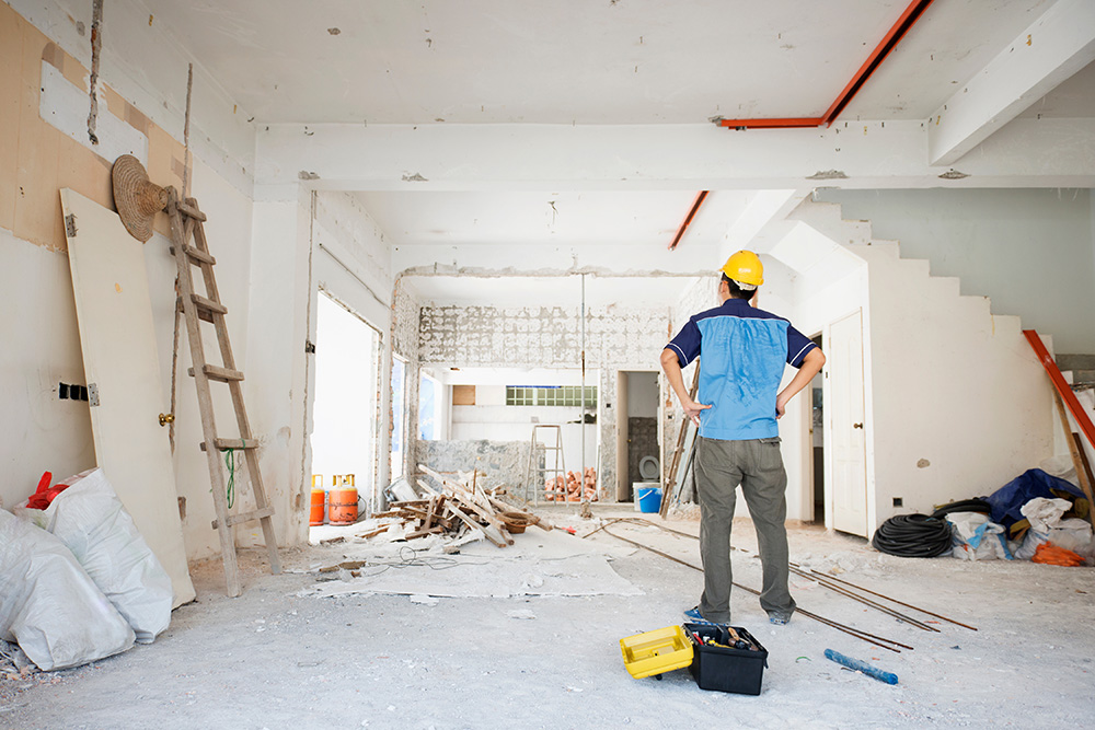 Worker assessing an interior space mid-renovation